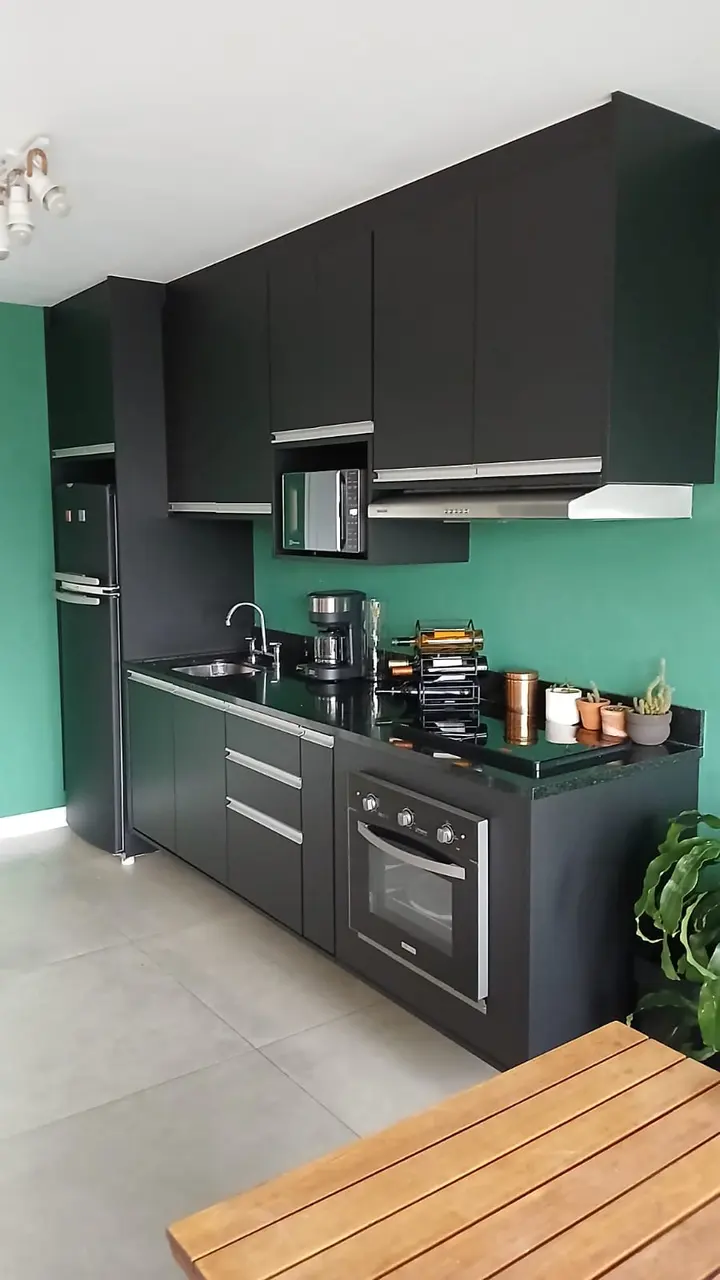 Cozinha com armários em cor sólida preta revestidos pela AM Adesivos